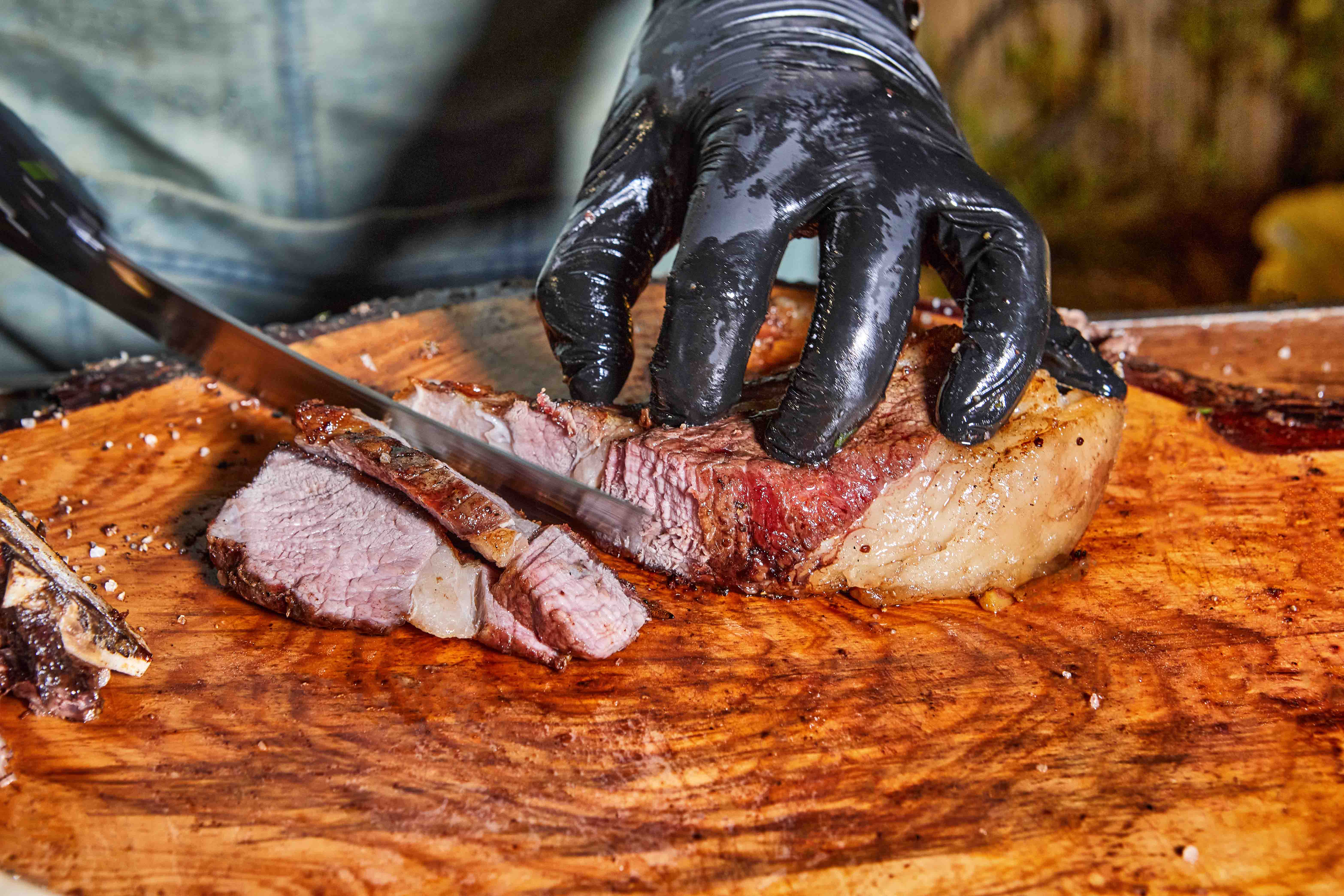 Chef fatiando carne defumada sobre uma tábua